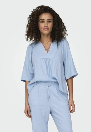 Haut bleu clair, à coupe décontractée, avec des manches courtes et un décolleté en V, associé à un pantalon assorti avec une taille ajustable par cordon.