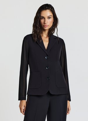 Schwarzer Blazer mit strukturiertem Design, ausgestattet mit Schalkragen, vier Frontknöpfen und transparenten langen Ärmeln. Zwei Fronttaschen sind ebenfalls enthalten.