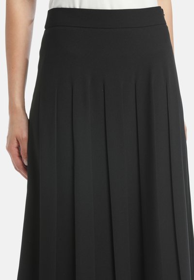 Fustă plisată neagră cu un elastic în talie, realizată dintr-un material moale. Prezintă pliseuri verticale pe toată lungimea, oferind un aspect fluid.