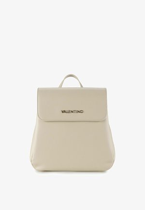 Beige leren rugzak met een gladde textuur, voorzien van een klepsluiting en een in reliëf gedrukt merknaam in goud. Heeft een bovenhandvat om te dragen.