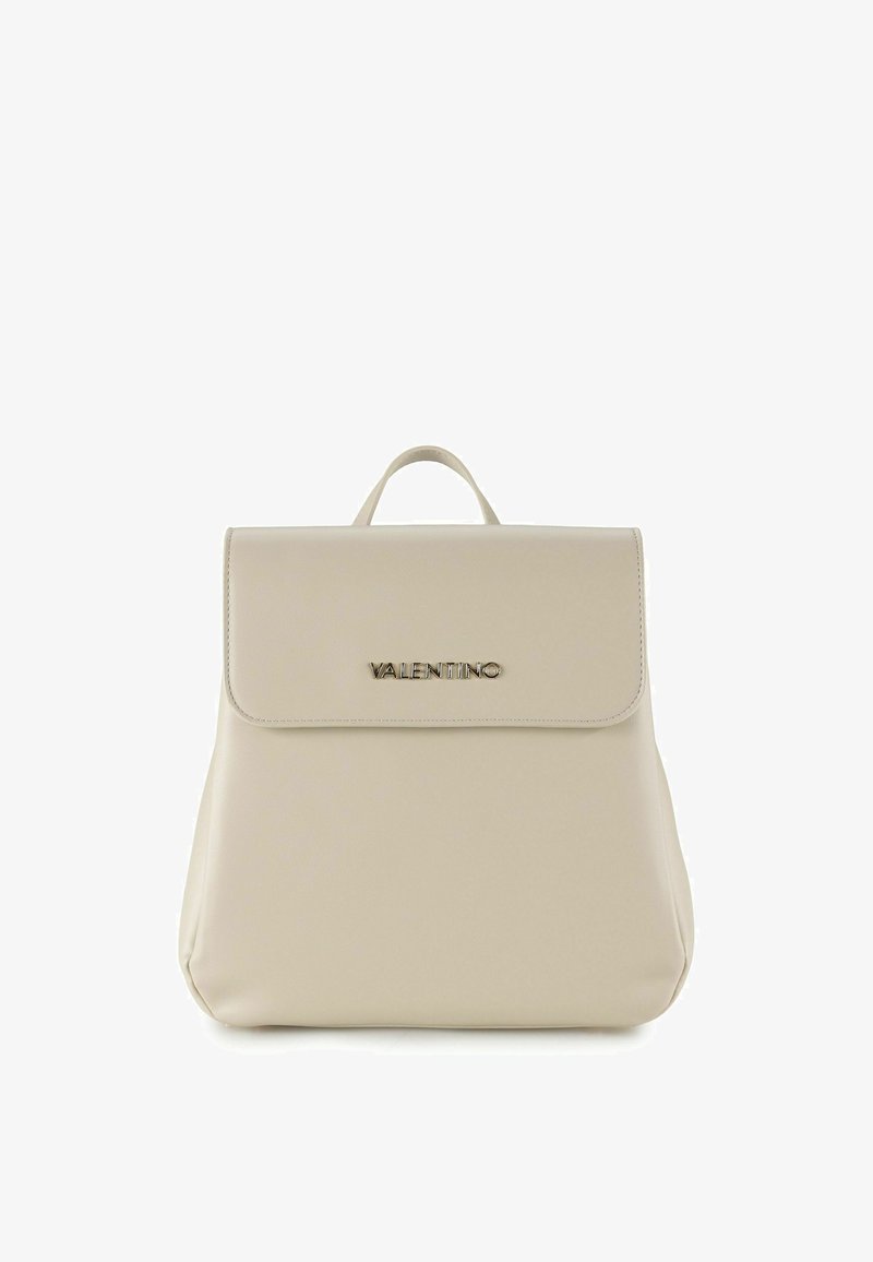 Sac à dos en cuir beige avec une texture lisse, doté d'un rabat à fermeture et du nom de la marque en relief doré. Comprend une poignée supérieure pour le transport.