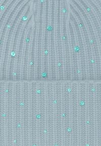 Beanie lavorato a maglia di colore blu chiaro con una texture a coste e paillettes turchesi sparse che abbelliscono la superficie.