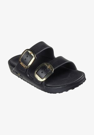 Tongs noires à enfiler avec deux larges sangles, boucles dorées et semelles en caoutchouc texturé. Fabriquées en matériau synthétique avec une finition lisse.