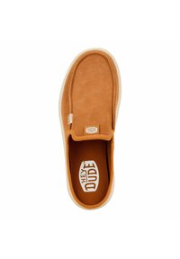 Tan suede slip-on shoe with a rounded shape and a white rubber sole. Features a patterned insole and a small logo tag on the upper.
