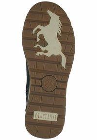 Semelle en caoutchouc marron avec une silhouette de cheval surélevée, un motif de grip texturé et le mot "MUSTANG" embossé près du talon. Taille 42.