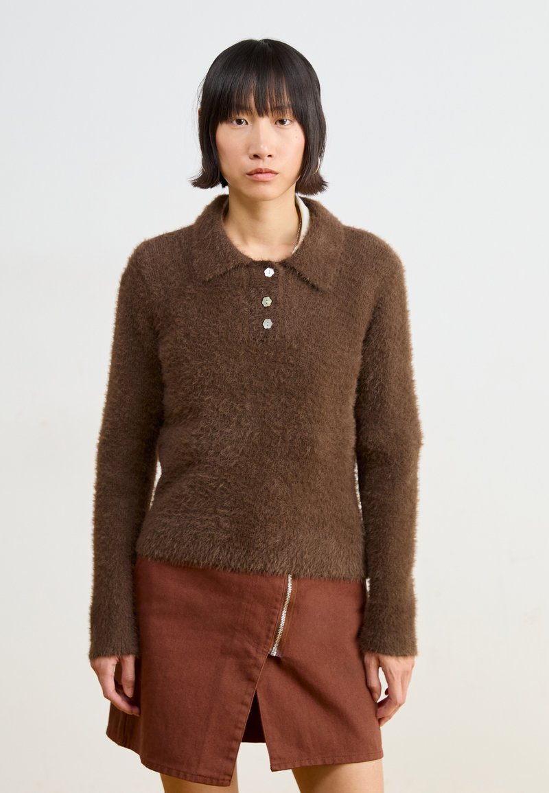 Brown fuzzy sweater with a collar and three-button placket, paired with a brown skirt featuring a front zipper and split hem.