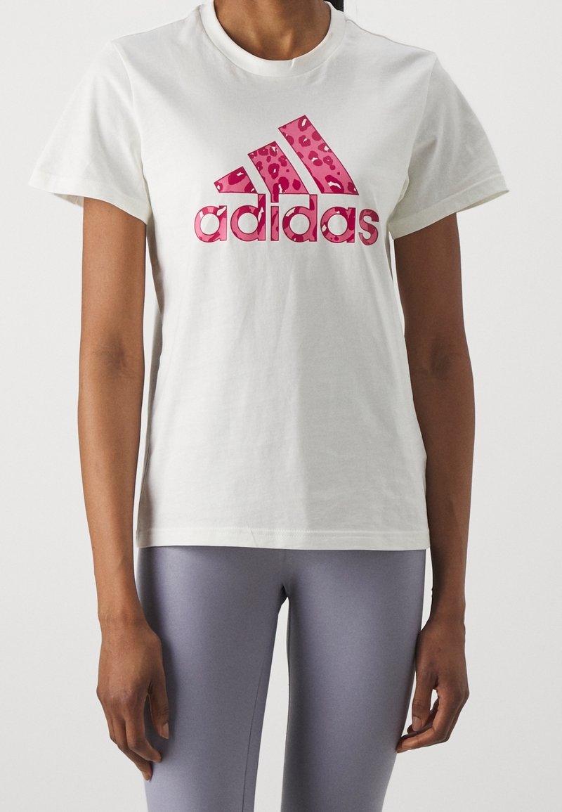 Bílé bavlněné tričko s růžovým leopardím logem Adidas. Tričko má klasický kulatý výstřih a krátké rukávy.