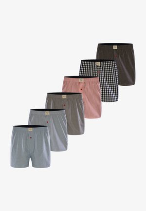 Seis pares de calzoncillos de hombre en varios colores y patrones: azul claro, gris, a cuadros en blanco y negro, rayas rojas y un sólido gris oscuro.