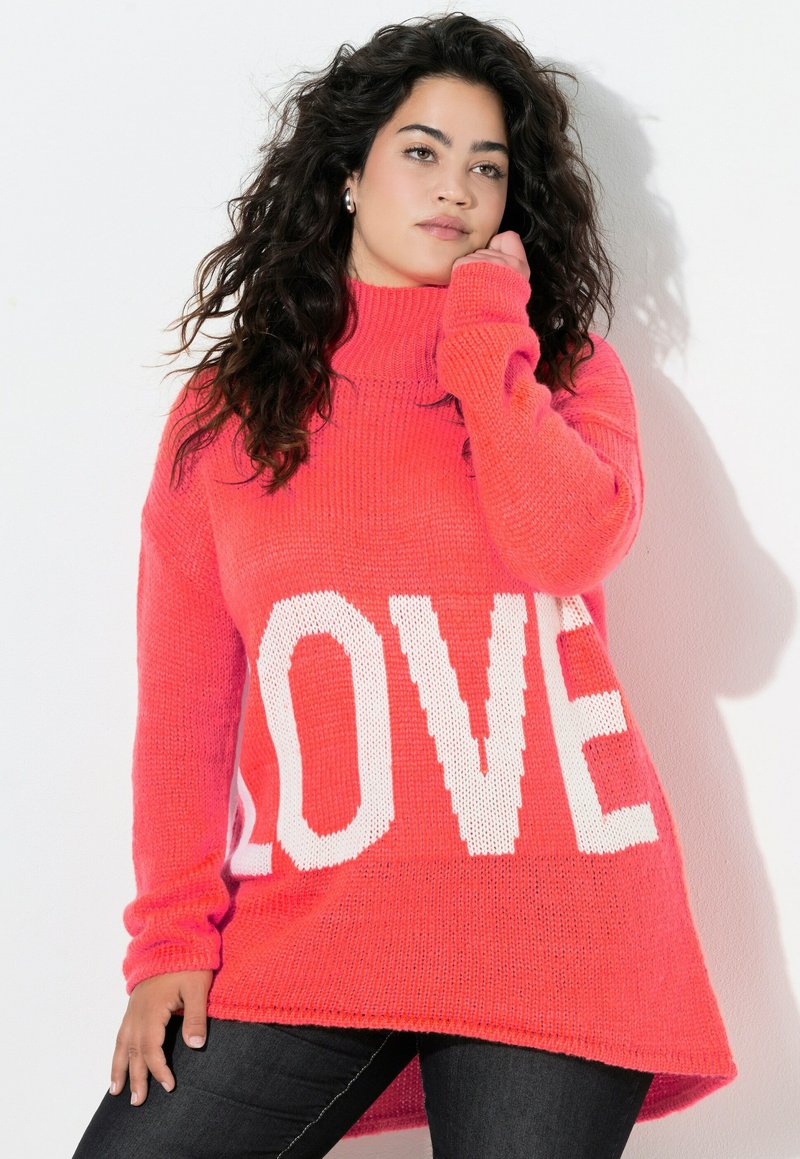 Pullover in leuchtendem Pinkstrick mit hohem Kragen und großzügigem Schnitt, der große weiße "LOVE"-Schriftzug auf der Vorderseite trägt. Strukturiertes Material.