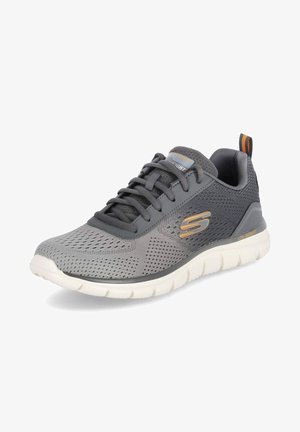 Scarpa atletica grigia con tomaia in rete, accenti arancioni a contrasto, punta arrotondata e suola bianca leggera; presenta un design con lacci e un colletto imbottito.
