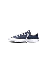 Pantof sport bleumarin cu talpă joasă, confecționat din pânză, cu șireturi albe, talpă de cauciuc și detaliu cu dungi negre, văzut din lateral pe un fundal alb.