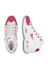 Biele športové topánky s červenými akcentmi, vybavené vycpávaným golierom, šnurovacím designom, textúrovanými prekrytiami a priehľadnou podrážkou pre lepšiu priľnavosť.