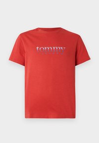 Camiseta de algodón roja con cuello redondo. "tommy" en azul y "JEANS" en blanco impresos en el pecho. Mangas cortas, corte regular.