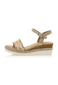 Sandalia de cuña beige con tiras de textil trenzadas, correa en el tobillo ajustable, tacón similar a la madera y acentos de yute. Suela de goma blanca para mayor agarre.