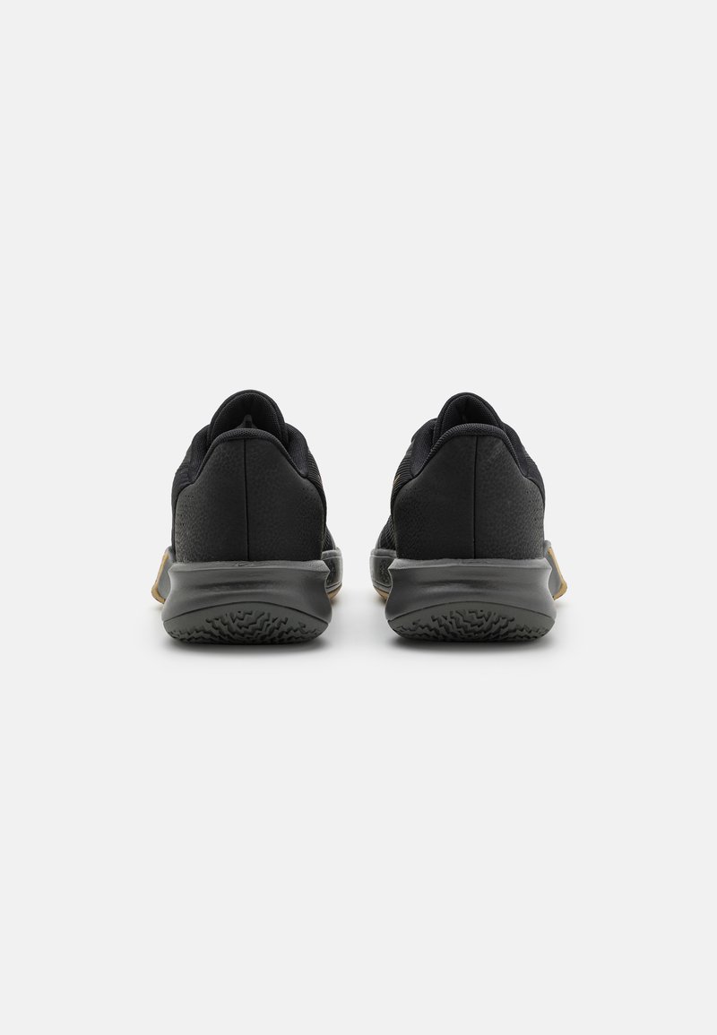 Zapatillas deportivas negras con un upper texturizado, que cuentan con un contrafuerte del talón liso y una suela de goma con un patrón de tracción distintivo.