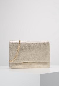 Gold metallic clutch bag with a textured surface, silver chain strap, and a metallic logo accent on the front. Rectangular shape.