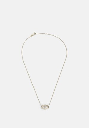 Silverkedja med ett ovalt hänge med en diamantliknande accent i mitten. Enkel design, mjuk textur.