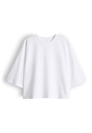 Maglietta bianca oversize a maniche corte con scollo rotondo, vestibilità ampia e spalle scese su sfondo uniforme.