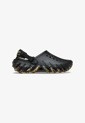 Black plastic clog with a camo-patterned sole, featuring ventilation holes, a back strap, and a textured, ridged base for grip.