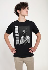 Černé tričko s centrálním grafickým motivem osoby v černobílé. Text zní "ODB JE PRO DĚTI." Krátké rukávy a klasický střih.