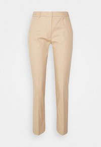 Beżowe spodnie dopasowane z gładkiego materiału. Posiadają płaski przód, wąski krój i proste nogawki bez widocznych ozdób.