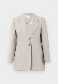 Μπεζ σακάκι με ένα κουμπί, προσαρμοσμένο και με V-στάντα γιακά, καθώς και δύο μπροστινές τσέπες, εκτεθειμένο σε απλό φωτεινό φόντο.