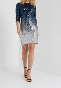 Puku duni zenye vikingu kutoka buluu wa baharini hadi fedha, zikiwemo mikono ya sentimita tatu, umbo la kufinya, na urefu mfupi. Viatu vya kisasa vya mblack.