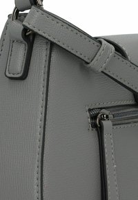 Graue strukturierte Lederhandtasche mit einer Reißverschlusstasche, stabilen Trägern und kontrastierenden Nähten für zusätzliche Details.