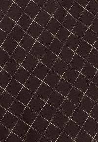 Brązowa tkanina z diamentowym wzorem utworzonym przez małe beżowe kropki. Tekstura wydaje się gładka z dzianinowym wykończeniem.