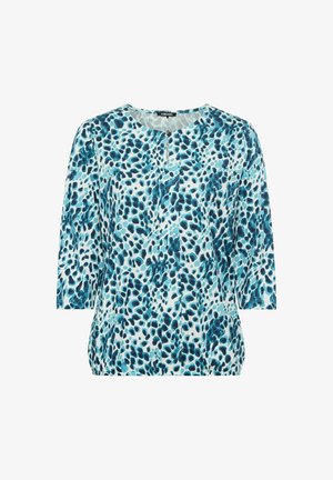 Lässig geschnittenes Oberteil mit einem hellblauen Hintergrund, verziert mit einem strukturierten, abstrakten Muster in Dunkelblau. Rundhalsausschnitt und Dreiviertelärmel.