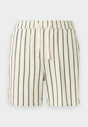 Shorts en éponge de couleur crème avec des rayures verticales noires et une ceinture élastique dotée de cordons de serrage crème.