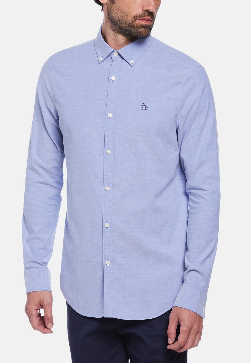 Lichtblauwe langemouwen shirt van zachte stof, met een button-down kraag, witte knopen en een klein geborduurd logo op de borst.
