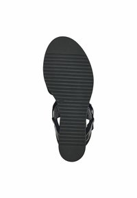 Semelle de sandale en caoutchouc noir avec des rainures horizontales pour l'adhérence ; la semelle intérieure présente une texture tissée ; design ouvert avec des sangles ajustables.