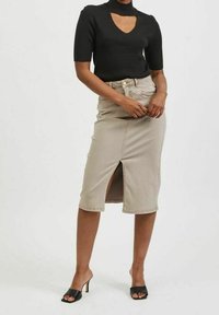 Béžová denimová úzká sukně s předním rozparkem, vysokým pasem a klasickým pětičtvercovým designem. Doplněná černým žebrovaným topem s krátkým rukávem.