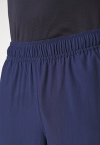 Navyblaue Stretchshorts mit einem elastischen Bund, glatter Textur und Flachnaht für zusätzlichen Komfort und Flexibilität.