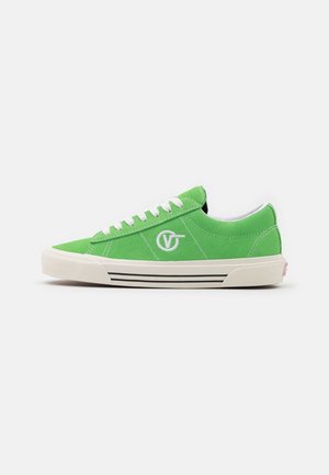 Grøn low-top sneaker med hvide snørebånd, hvid gummisål med sorte striber og en hvid cirkulær logo på siden.