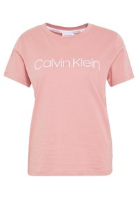 Růžové bavlněné tričko s kulatým výstřihem a krátkými rukávy, s b�ílým logem "Calvin Klein" přes přední stranu. Hladký povrch.