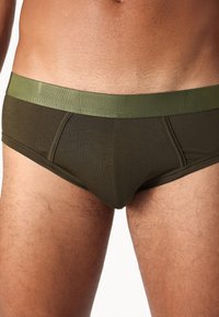 Men's briefs in dark olive green color, featuring a contrasting light green waistband, smooth texture, and a fitted, low-rise design.