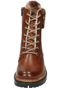 Botín de cuero marrón con forro de pelo sintético, cremallera de metal y cordones beige. Presenta un acabado texturizado y suela negra resistente.