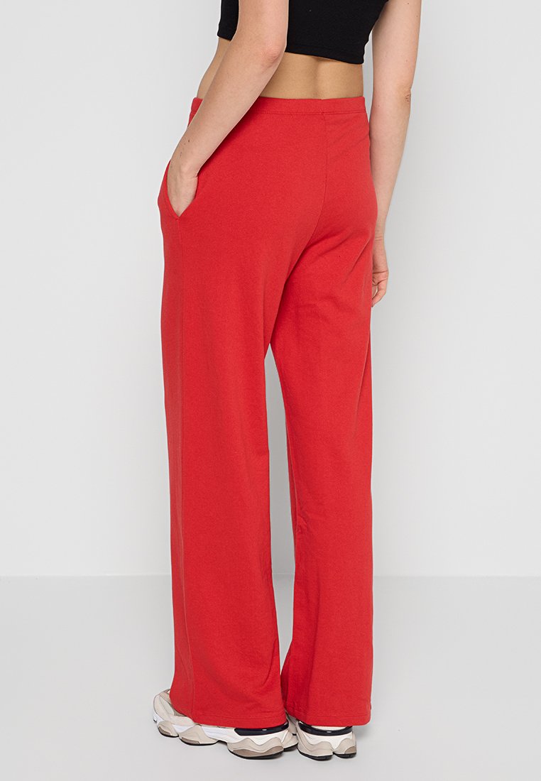 Pantalons larges rouges en tissu doux, dotés d'une taille élastique haute et de poches latérales. Convient pour un usage décontracté.