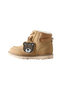 Tan Kinderschneestiefel mit weißem Fleecefutter und einer Aufnähung in Form eines Teddybären neben den Schnürsenkeln.