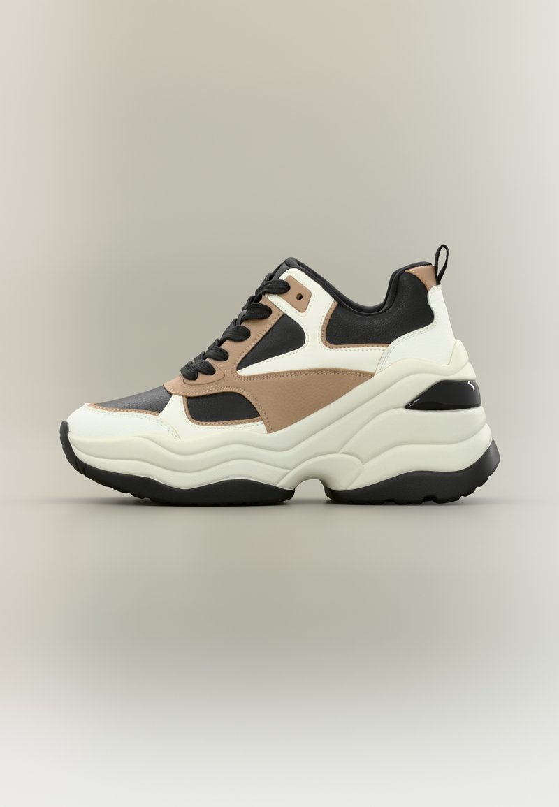 Gruba sneakerka w białej, czarnej i beżowej kolorystyce, z teksturowanym wykończeniem i grubą gumową podeszwą. Zawiązywana na czarne sznurówki i z czarnymi detalami.
