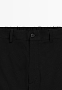 Zwarte broek met tailleband, knoopsluiting, ceintuurlussen en elastische achterkant voor een verstelbare pasvorm.