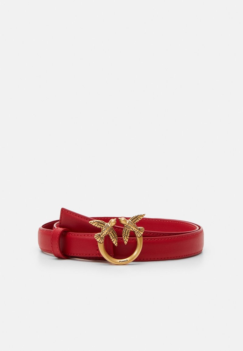 Ceinture en cuir rouge avec une boucle ronde en or ornée de deux oiseaux détaillés se faisant face.