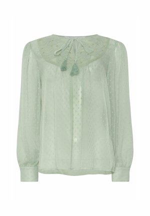 Vaaleanvihreä pusero, joka on valmistettu läpinäkyvästä kankaasta. Ominaisuuksiin kuuluu kuvioitu täplämalli, brodeerattu kaula-aukko ja kaksi tupsua takana kaulassa.