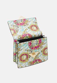 Laukkku, jossa läppä auki, sinisellä, kullanvärisellä ja vaaleanpunaisella koristeellisella barokki-kuviolla ja kultaisella kolmionmuotoisella lukolla.