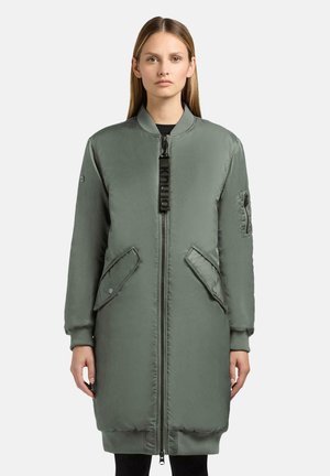 Cappotto lungo imbottito verde con zip frontale, polsini a coste, tasche laterali e una tasca applicata sul maniche. Finitura liscia dallo stile bomber.