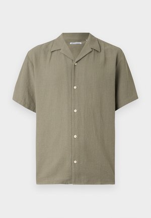 Πουκάμισο με κοντό μανίκι σε ελιά πράσινο χρώμα, με κουμπιά και γιακά τύπου κατασκήνωσης, κατασκευασμένο από υφασμένο ύφασμα, απλωμένο επίπεδα σε λευκό φόντο.
