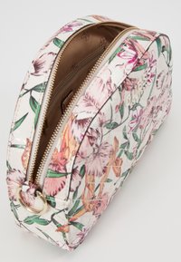 Blomstret kosmetiktaske med en hvid tekstureret overflade, prydet med pink og orange blomster, guld metaldele og en lynlåslukning. Glat inderside.