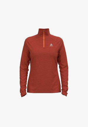 Haut de sport rouge rouille à manches longues avec fermeture éclair au quart et petit logo blanc sur la poitrine, présenté sur un fond blanc uni.